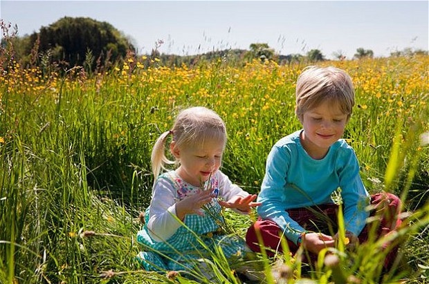 Two young children discovering the small wildlife in the surrounding countryside which is protected by our sustainable practices