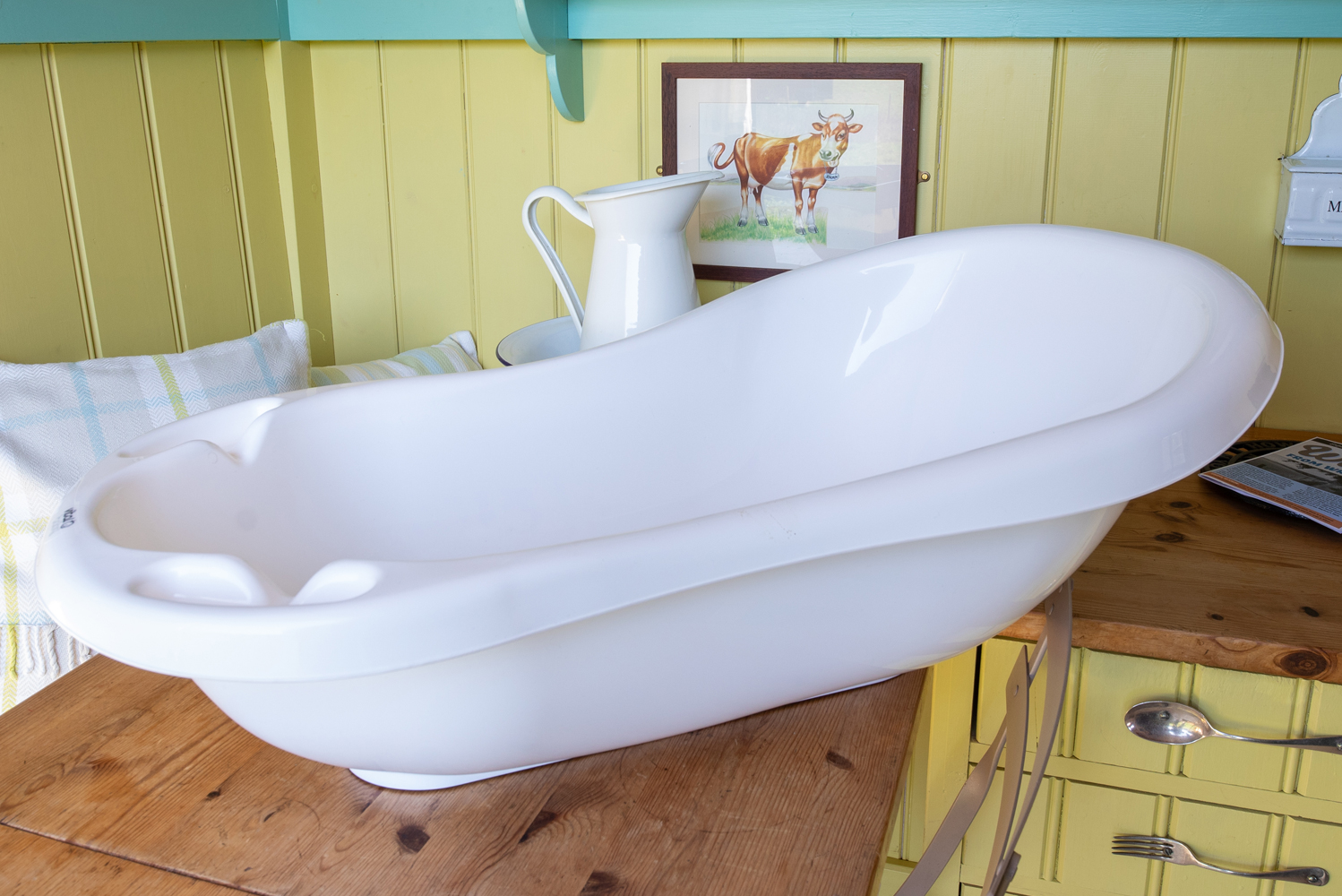 White baby bath on the wooden table in one of our shepherd's huts for child friendly holidays