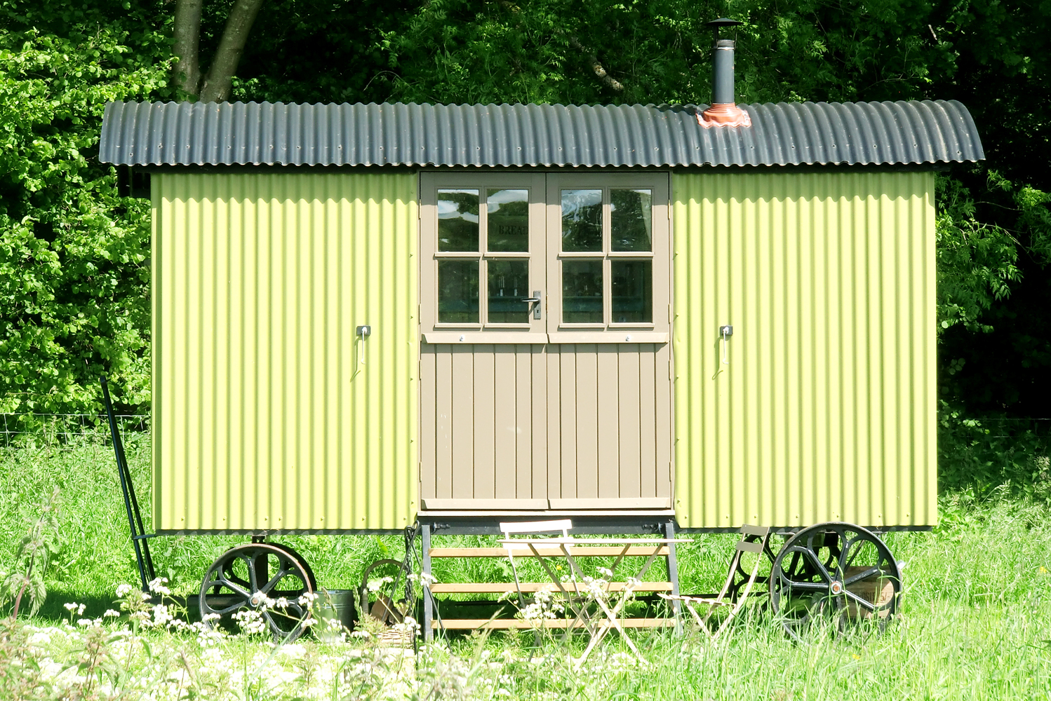 Boundary shepherd's hut is perfect for family glamping holidays and is painted a pale green and double doors make the interior feel more spacious