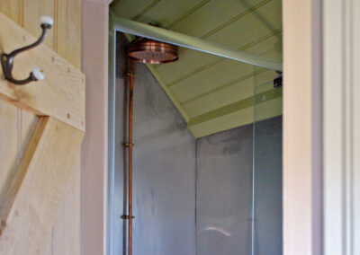 The Wriggly Inn is an ensuite shepherds hut and the shower has copper piping and a copper shower head